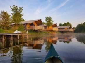 Tents with kitchen and bathroom near a pond